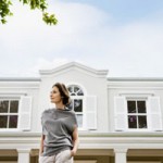 Woman in front of large home