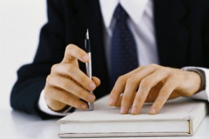 Businessman's hands on book, holding pen