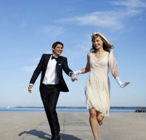 Newlyweds running on a beach