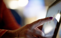 A woman uses a touch screen device.